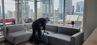 Man cleans upholstery on sectional.