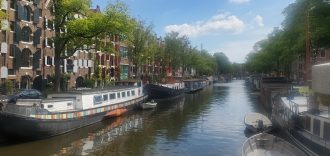 Quaint houseboats line a canal in Amsterdam.